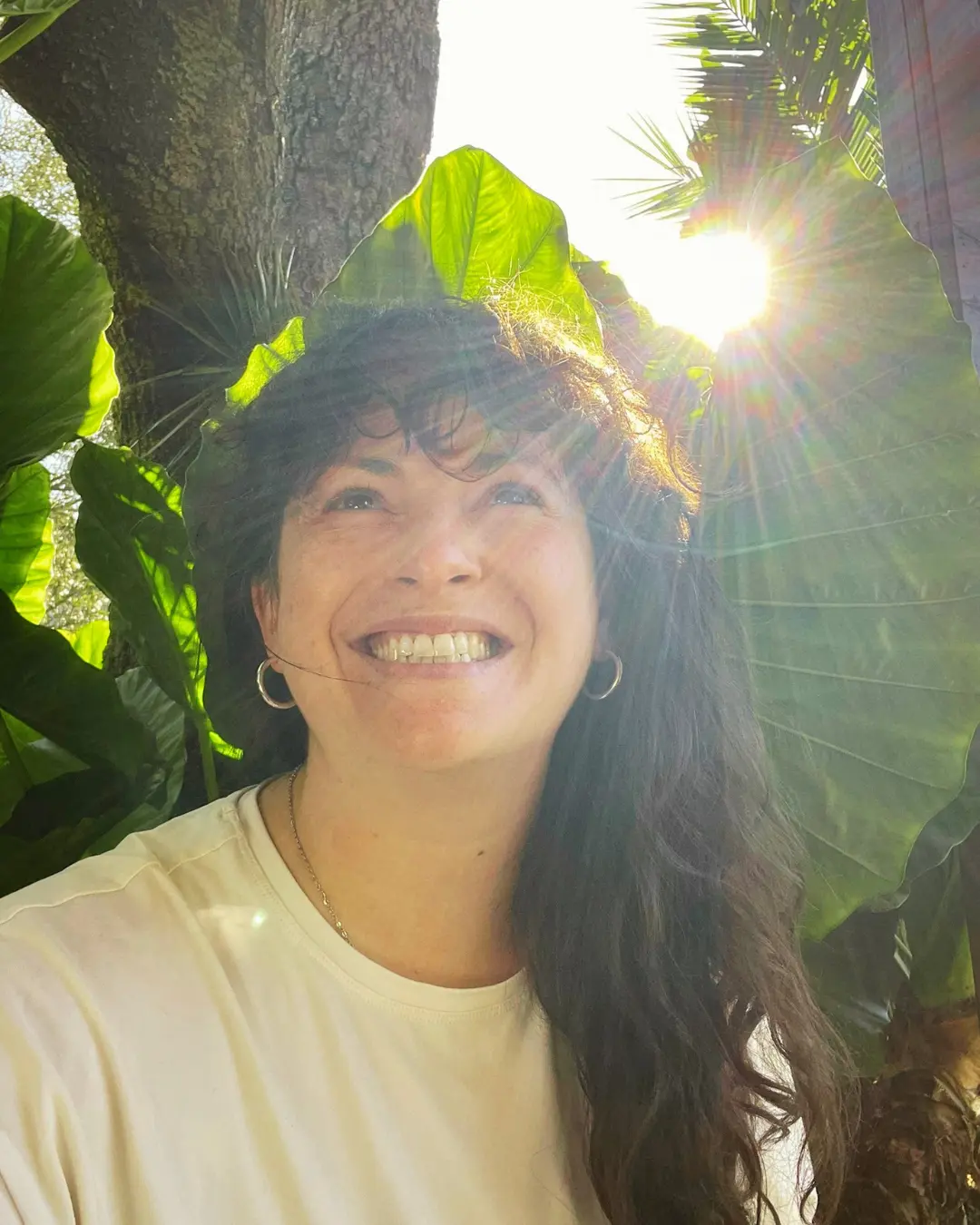 Kerry smiling in warm afternoon light among garden leaves