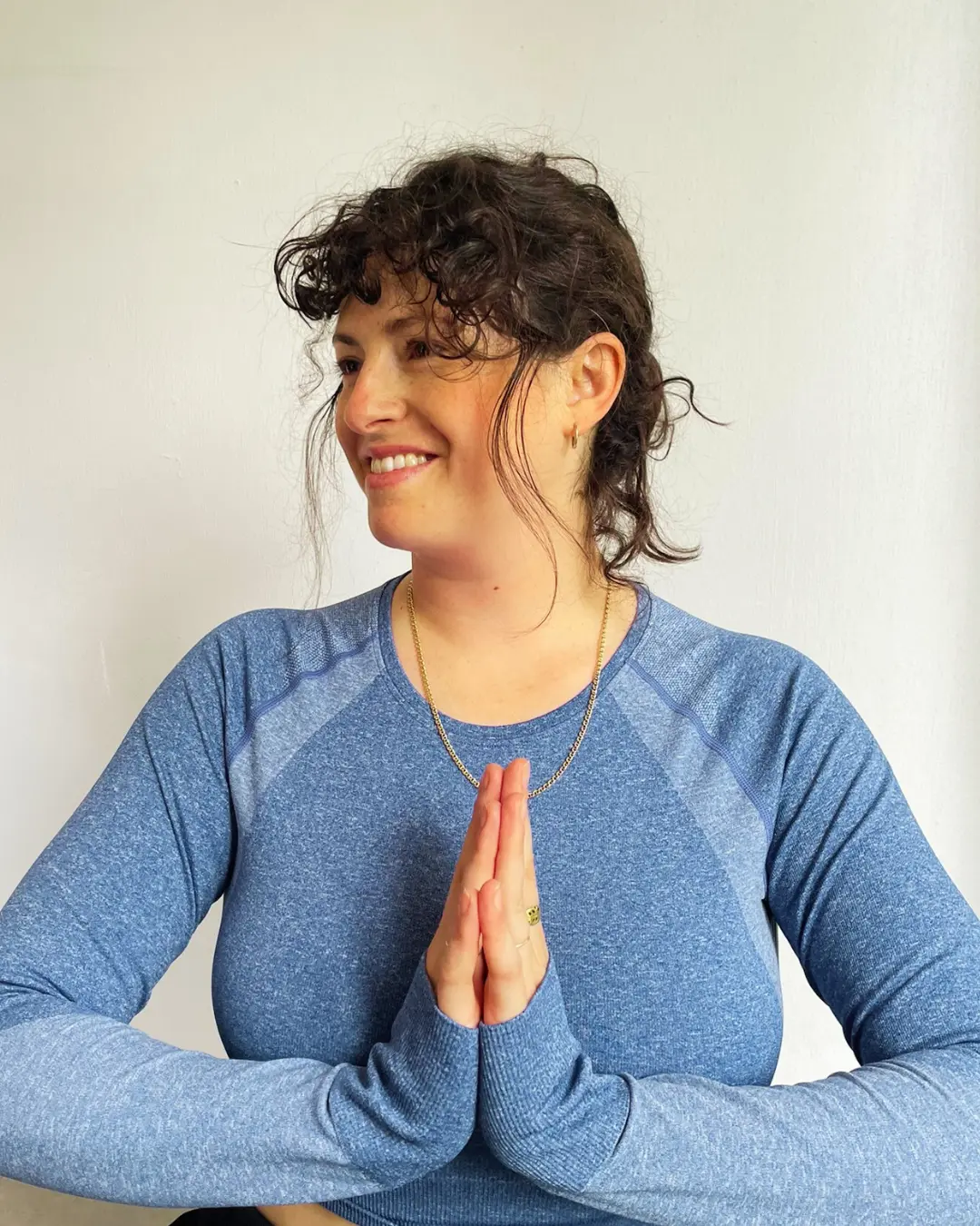 Kerry in blue, smiling with her hands together