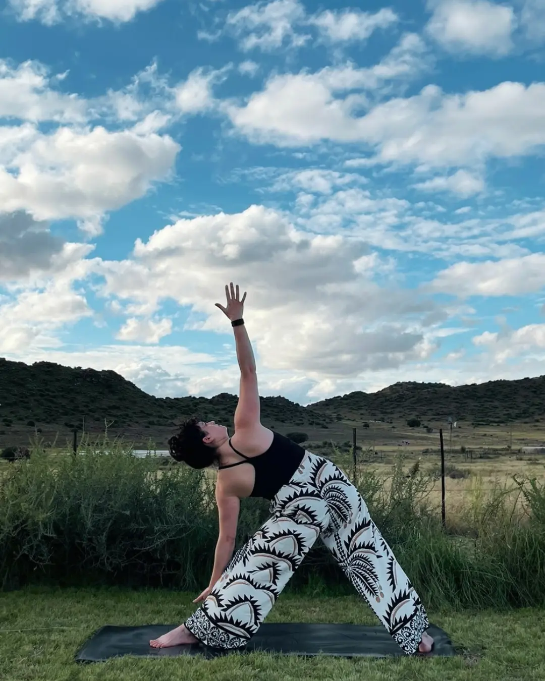 Kerry practising yoga outdoors beneath an open sky